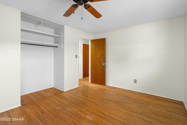 unfurnished bedroom featuring ceiling fan, wood-type flooring, and a closet