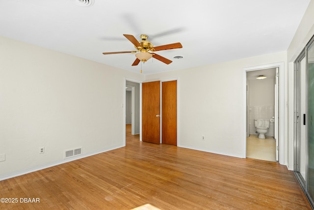 unfurnished bedroom featuring ensuite bathroom and light wood-type flooring