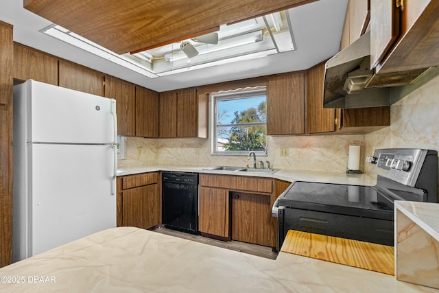 kitchen with sink, stainless steel electric range, black dishwasher, white refrigerator, and a tray ceiling