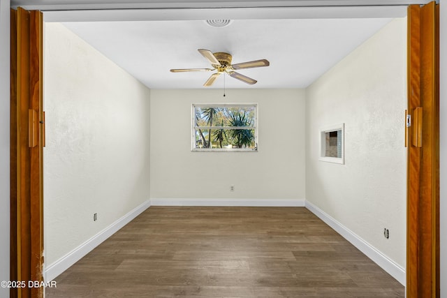 spare room featuring dark hardwood / wood-style flooring and ceiling fan