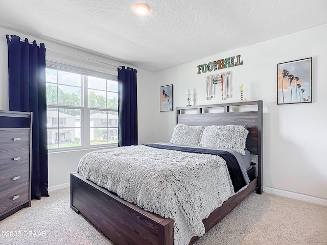 bedroom featuring a textured ceiling and light carpet