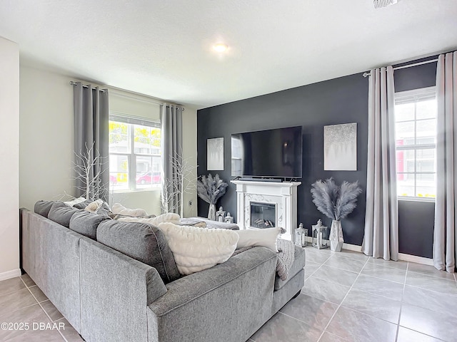 tiled living room featuring a high end fireplace