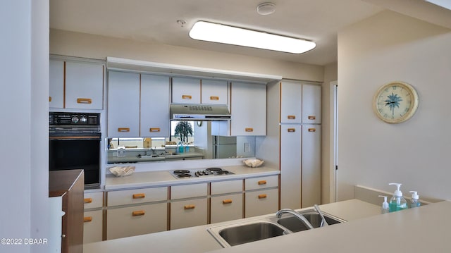 kitchen with black oven, fridge, sink, and white gas stovetop