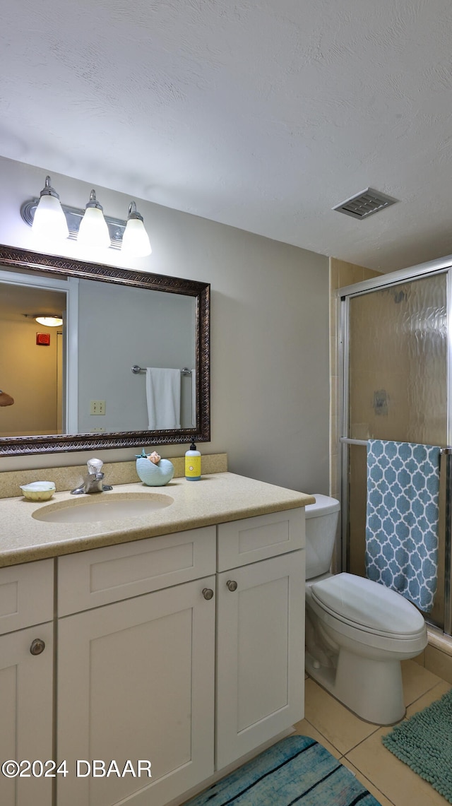 bathroom featuring walk in shower, tile patterned flooring, vanity, and a textured ceiling