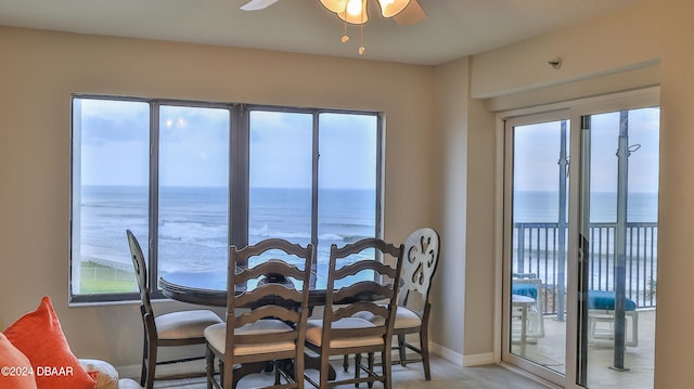 dining area featuring a water view and ceiling fan