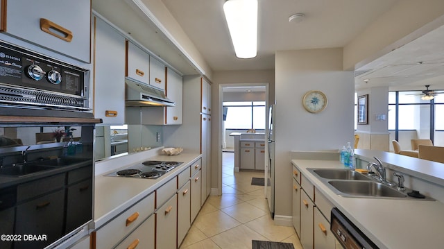 kitchen with a wealth of natural light, sink, light tile patterned floors, and white cabinets