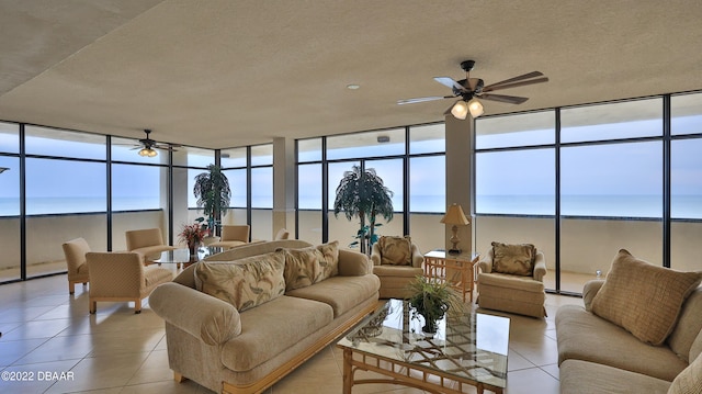 sunroom / solarium with ceiling fan and a water view