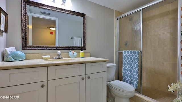 bathroom featuring vanity, toilet, and a shower with door