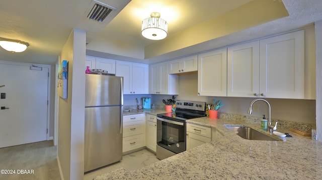 kitchen featuring light stone countertops, white cabinets, sink, and stainless steel appliances