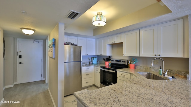 kitchen featuring white cabinets, light stone countertops, sink, and appliances with stainless steel finishes