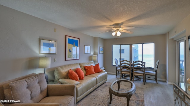 living room featuring a textured ceiling, hardwood / wood-style flooring, and ceiling fan