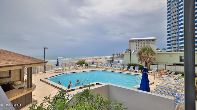 view of swimming pool featuring a patio and a water view