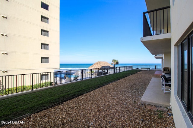 view of yard with a water view, a balcony, and a patio area