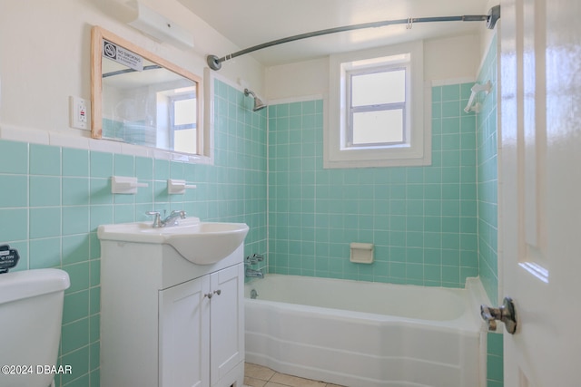 full bathroom featuring tiled shower / bath, vanity, tile patterned floors, toilet, and tile walls