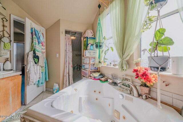 bathroom featuring a tub, tile patterned floors, and vaulted ceiling