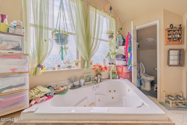 bathroom featuring vaulted ceiling, toilet, and a relaxing tiled tub