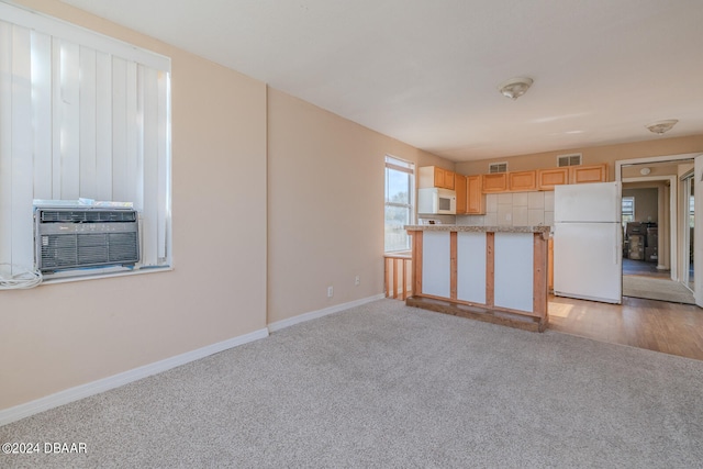 kitchen featuring light hardwood / wood-style flooring, cooling unit, light brown cabinetry, and white appliances