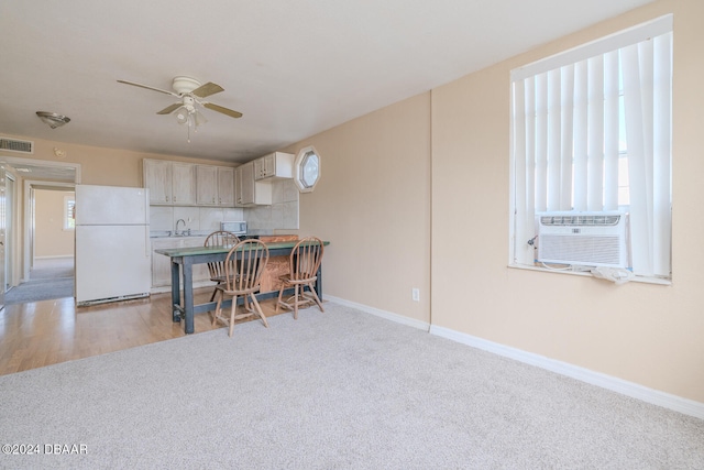 kitchen with sink, ceiling fan, white appliances, cooling unit, and light wood-type flooring