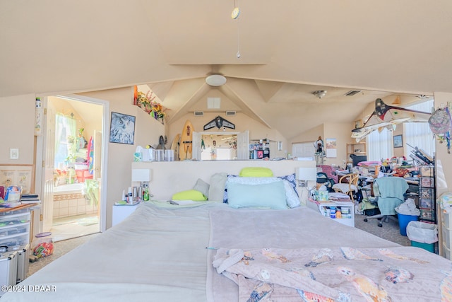 carpeted bedroom with ensuite bathroom and lofted ceiling