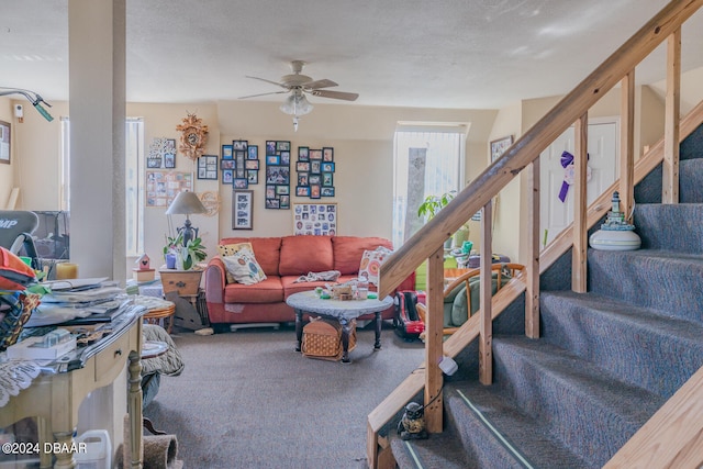 carpeted living room with ceiling fan and a textured ceiling