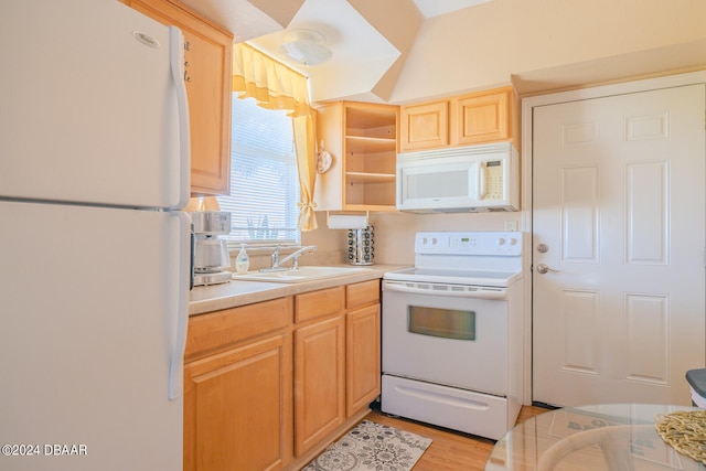 kitchen featuring light brown cabinets, light wood-type flooring, sink, and white appliances