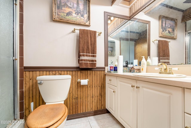 bathroom featuring toilet, vanity, wooden walls, and tile patterned flooring