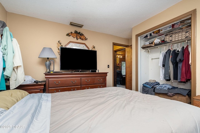 bedroom with a textured ceiling and a closet