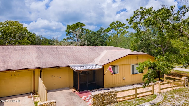 view of front of home featuring a garage and a sunroom