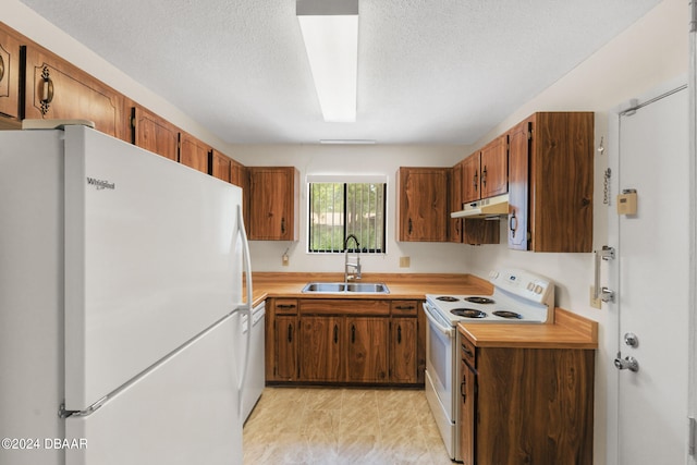 kitchen with white appliances, sink, and a textured ceiling