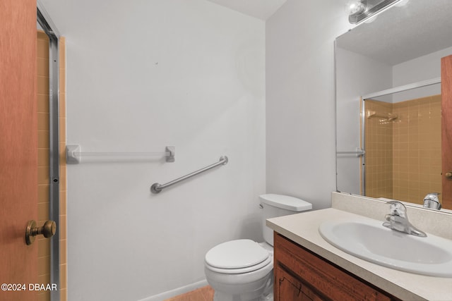 bathroom with vanity, toilet, and a tile shower