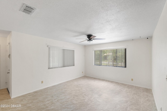 spare room with a textured ceiling and ceiling fan