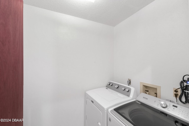 laundry room featuring separate washer and dryer and a textured ceiling