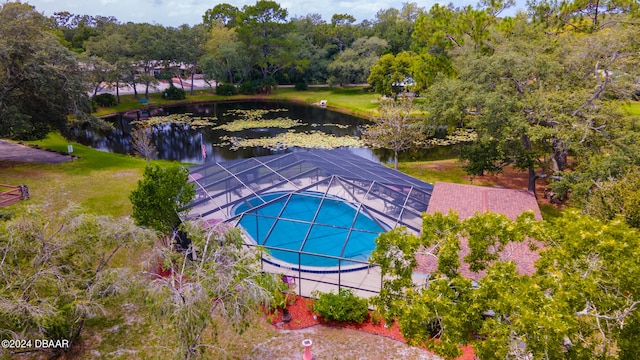 view of swimming pool featuring a lawn, a lanai, and a water view