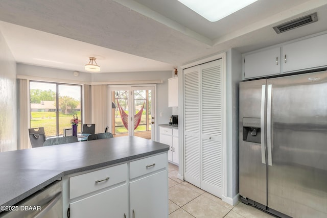 kitchen featuring visible vents, white cabinets, light tile patterned floors, dark countertops, and stainless steel appliances