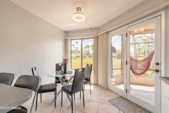 dining area with light tile patterned floors and a textured wall