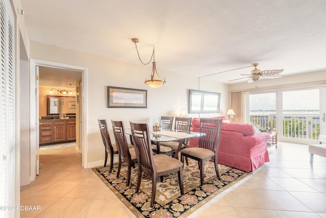 dining space featuring light tile patterned floors, baseboards, and ceiling fan