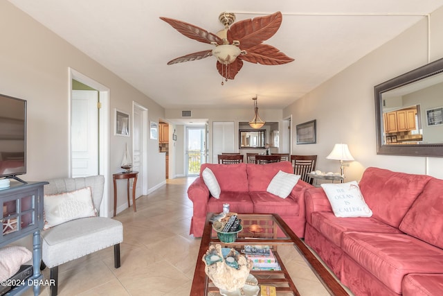 living area featuring light tile patterned floors, baseboards, and a ceiling fan