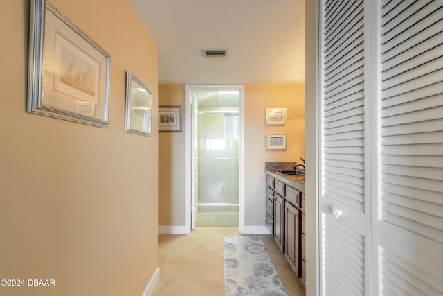 bathroom with visible vents, a closet, baseboards, tile patterned floors, and a stall shower