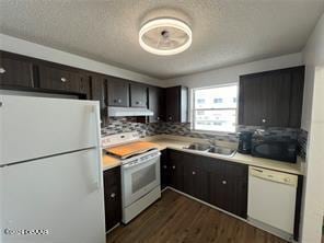 kitchen with dark hardwood / wood-style flooring, dark brown cabinetry, sink, backsplash, and white appliances