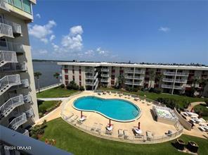 view of swimming pool featuring a water view and a yard