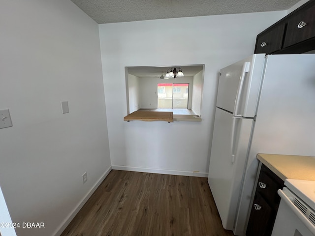 kitchen with a textured ceiling, white fridge, dark hardwood / wood-style flooring, and a notable chandelier