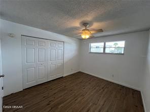 unfurnished bedroom with a textured ceiling, dark hardwood / wood-style flooring, ceiling fan, and a closet