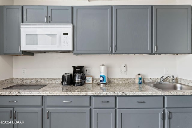 kitchen with black electric cooktop, gray cabinets, and sink