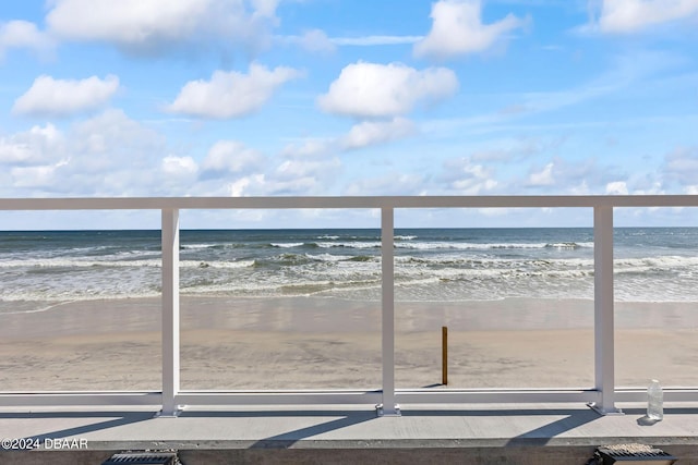 balcony with a water view and a beach view