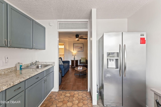 kitchen with stainless steel fridge, tile patterned floors, a textured ceiling, ceiling fan, and sink