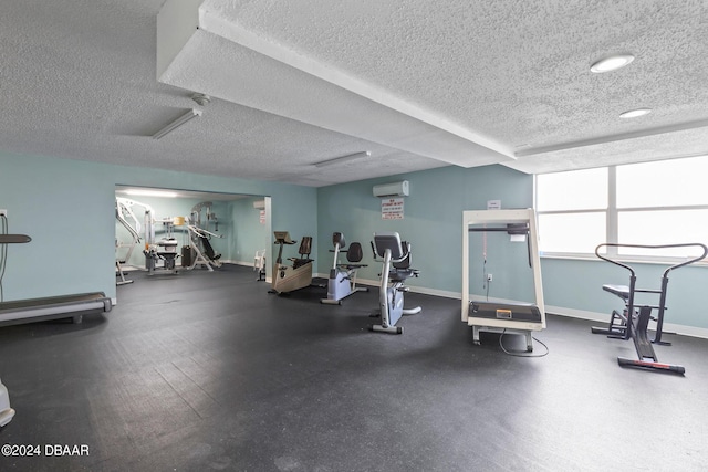 workout area with a wall mounted AC and a textured ceiling