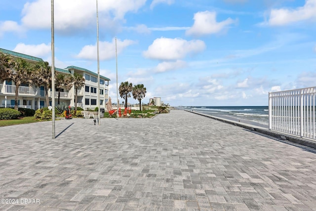 view of home's community featuring a water view and a beach view