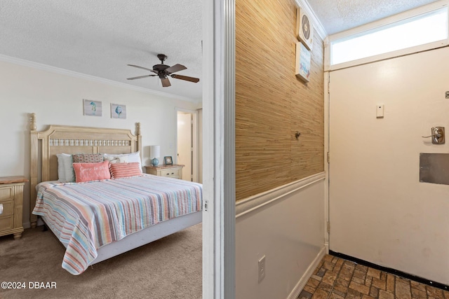 bedroom with a textured ceiling, ceiling fan, crown molding, and wooden walls