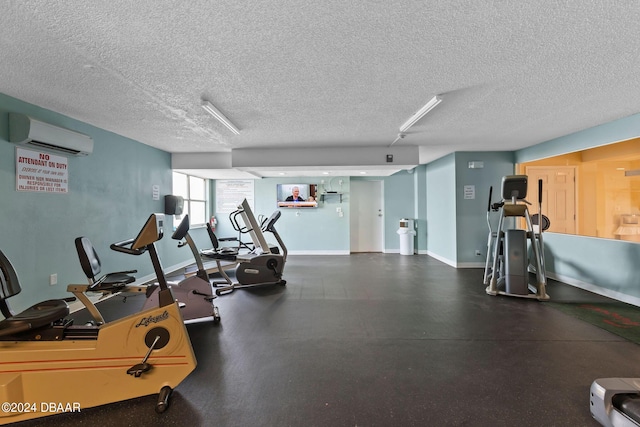 workout area with a textured ceiling and a wall unit AC