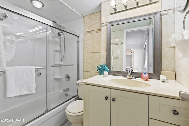 full bathroom with vanity, enclosed tub / shower combo, tile walls, and toilet